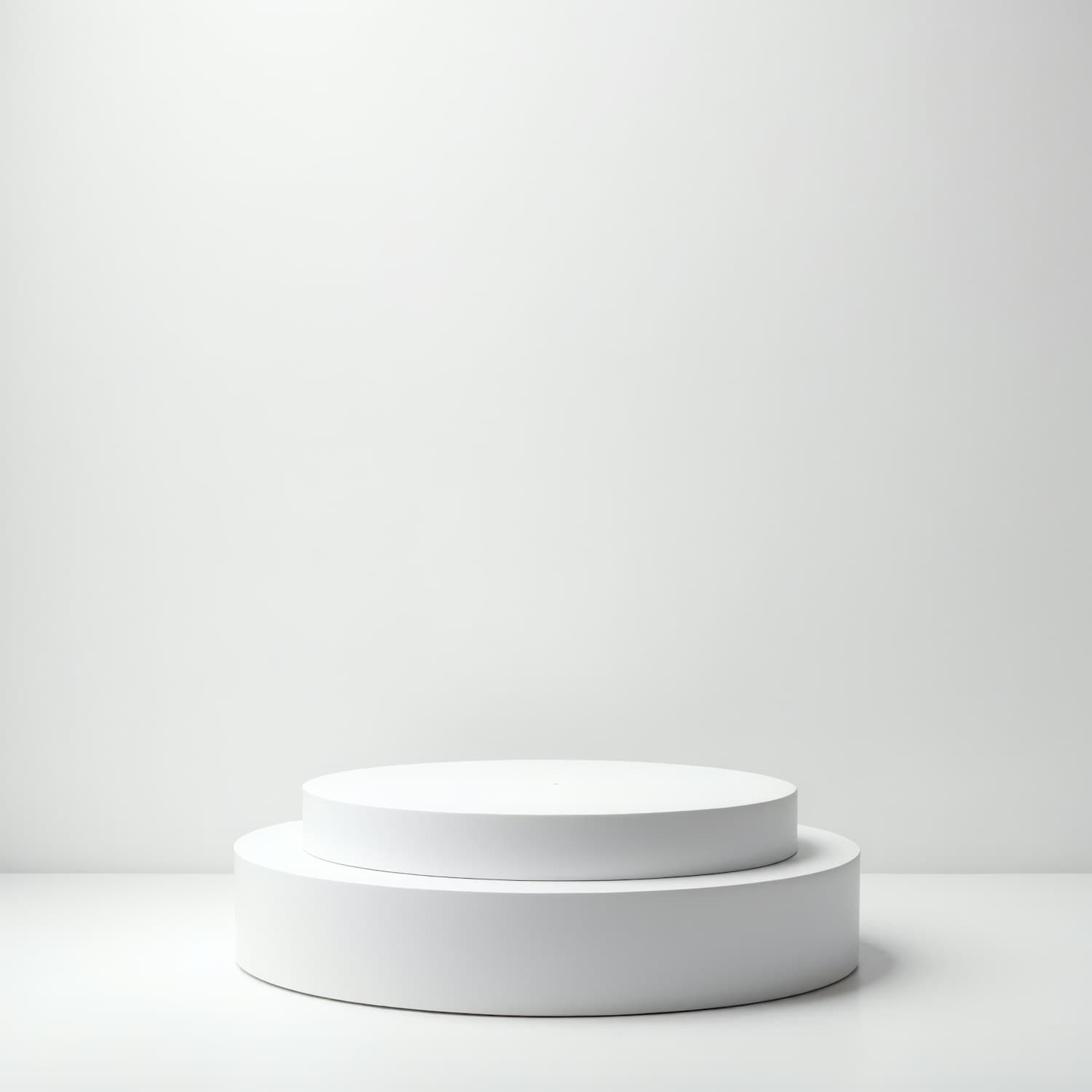Two stacked round white plinths on a seamless pale grey background